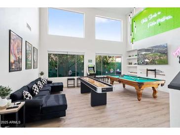 Spacious game room featuring a pool table, shuffleboard table, arcade game, and comfortable seating area at 29228 N 48Th St, Cave Creek, AZ 85331