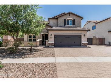 Charming two-story home featuring a spacious driveway, desert landscaping, and a two-car garage at 3067 E Trigger Way, Gilbert, AZ 85297
