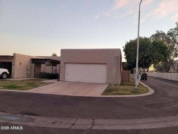 Beige single-story home featuring an attached two-car garage and desert landscaping at 3345 E University Dr # 47, Mesa, AZ 85213