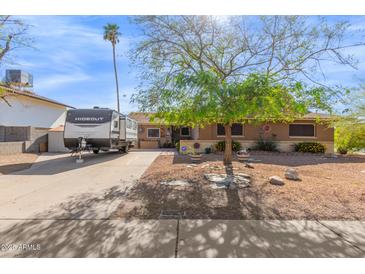 Charming single-story home with a well-maintained front yard and a RV trailer parked in the driveway at 4804 S Elm St, Tempe, AZ 85282