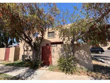 A charming townhome featuring desert landscaping and mature shade trees, providing a comfortable outdoor setting at 5002 N 41St Ave, Phoenix, AZ 85019