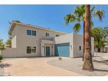 Contemporary home showcasing clean lines, a blue garage door, desert landscaping, and palm trees at 1131 E Bishop Dr, Tempe, AZ 85282
