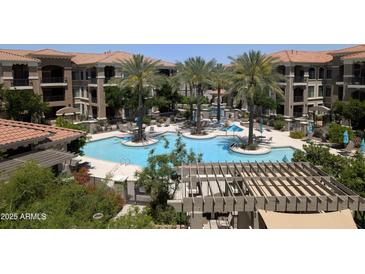 Expansive community pool features sun loungers, palm trees, and multiple swim areas at 11640 N Tatum Blvd # 3035, Phoenix, AZ 85028