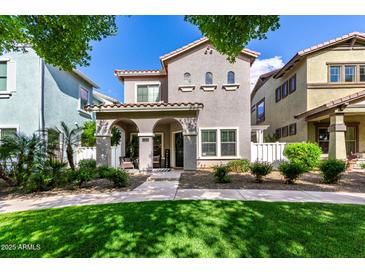 Charming two-story home features a covered porch, landscaped front yard, and well-maintained lawn, creating inviting curb appeal at 1324 S Banning St, Gilbert, AZ 85296