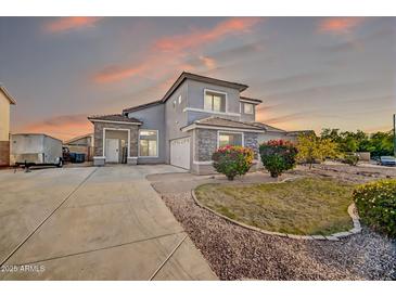 Charming two-story home featuring a well-manicured lawn, stone accents, and a spacious driveway at 13625 W Peck Ct, Litchfield Park, AZ 85340