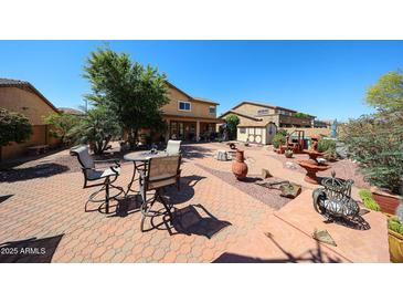 Extensive backyard space featuring various seating areas, desert landscaping, and a shed at 22022 W Moonlight Path, Buckeye, AZ 85326