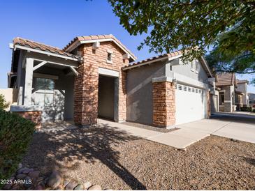 Charming single-story home with a brick facade and a well-maintained desert-style front yard at 35721 N Zachary Rd, Queen Creek, AZ 85144