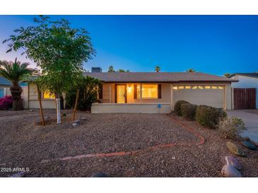 Charming single-story home with a landscaped front yard and an attached two-car garage at 3624 E Hearn Rd, Phoenix, AZ 85032