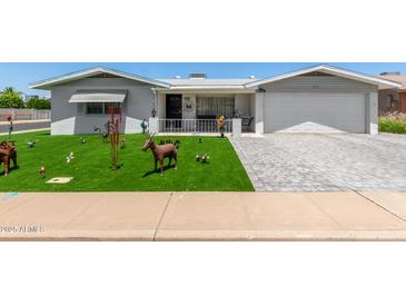 Charming home featuring an immaculate lawn, manicured landscaping, and brick-paved driveway at 5122 E Emerald Cir, Mesa, AZ 85206