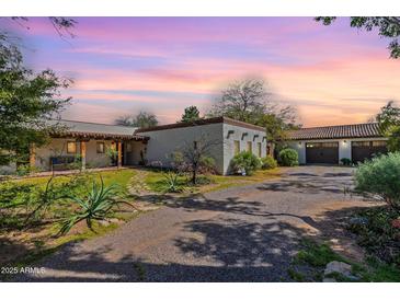 Charming single story home featuring lush landscaping, a detached garage and a stone pathway at 6418 E Sunnyside Dr, Scottsdale, AZ 85254