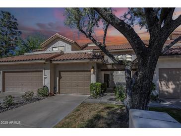 Charming townhome with a red tile roof and a two-car garage, complemented by mature landscaping at 9705 E Mountain View Rd # 1096, Scottsdale, AZ 85258