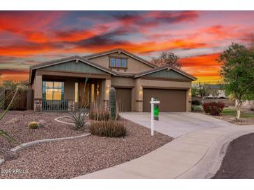 Charming single-Gathering home featuring desert landscaping, a three-car garage, and a welcoming front porch at 12702 W Dove Wing Way, Peoria, AZ 85383