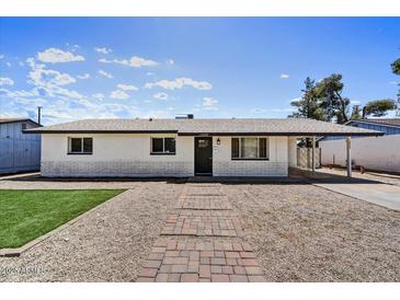 Charming single story home with a well-manicured lawn and inviting brick pathway leading to the front door at 15049 N 25Th Pl, Phoenix, AZ 85032
