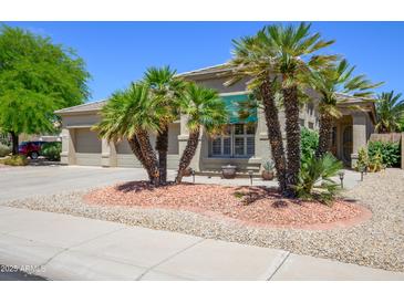 Charming single-story home boasts a low-maintenance landscape with palm trees and neutral exterior at 17710 W Buena Vista Dr, Surprise, AZ 85374
