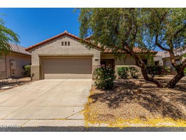 Charming home with a two-car garage, desert landscaping, and a beautiful mature shade tree at 19963 N Window Rock Dr, Surprise, AZ 85374