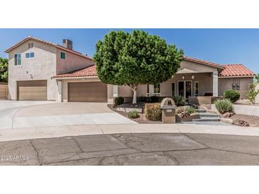 Charming home featuring a well-maintained front yard, attached garage, and stylish desert landscaping at 2254 E Becker Ln, Phoenix, AZ 85028