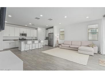 Open-concept living space featuring tile floors, a modern sofa, and a well-appointed kitchen at 23068 E Stacey Rd, Queen Creek, AZ 85142