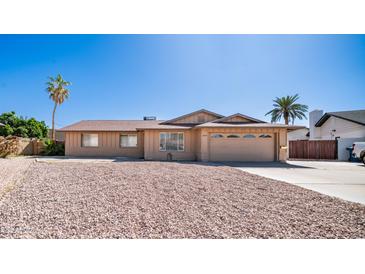 Charming single-story home with a two-car garage, desert landscaping, and mature palm trees at 2337 E Riviera Dr, Tempe, AZ 85282