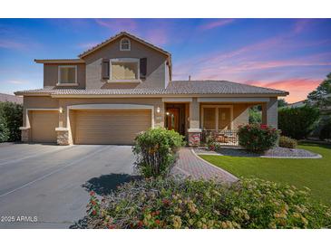 Charming two-story home with a three-car garage, covered porch, and mature landscaping under a colorful sky at 2886 E Hazeltine Way, Chandler, AZ 85249