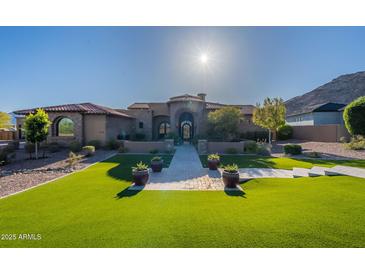 Elegant home featuring a lush lawn, meticulously arranged potted plants, and a paved walkway to a grand entrance at 3118 W Glenhaven Dr, Phoenix, AZ 85045