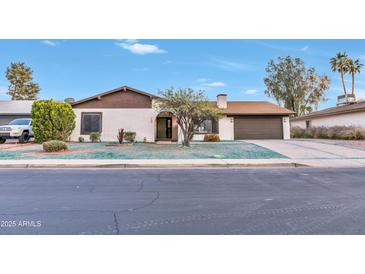 Charming home featuring a front lawn with a tree, driveway, and a two-car garage at 753 W Pampa Ave, Mesa, AZ 85210