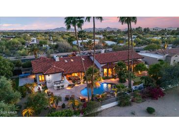 Expansive home exterior features a private pool, lush landscaping, and a red tile roof at 8514 E Country Club Trl, Scottsdale, AZ 85255