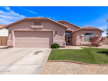 Charming single-story home featuring a two-car garage, desert landscaping, and a well-maintained lawn at 11266 E Dartmouth Cir, Mesa, AZ 85207