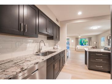 Modern kitchen featuring gray cabinetry, stainless steel appliances, and white backsplash at 1644 W Roma Ave, Phoenix, AZ 85013