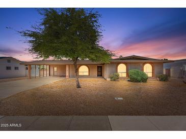 Charming single-story home featuring arched windows, desert landscaping, and a covered carport at 1902 E 8Th St, Mesa, AZ 85203