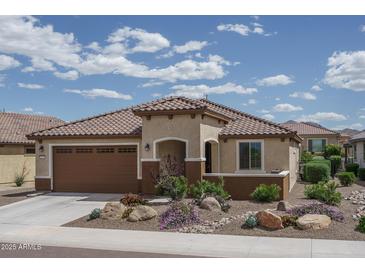 Charming single-story home featuring a tiled roof, well-manicured landscaping, and an attached two-car garage at 26017 W Maple Dr, Buckeye, AZ 85396