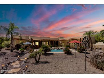 Inviting backyard featuring a pool with waterfall feature, desert landscaping, and patio furniture at 37809 N 9Th Pl, Phoenix, AZ 85086