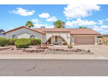 Charming single-story home featuring a tile roof and well-maintained desert landscaping in the front yard at 5126 W Las Palmaritas Dr, Glendale, AZ 85302