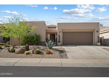 Charming single-story home featuring a low-maintenance desert landscape and a two-car garage at 6579 E Shooting Star Way, Scottsdale, AZ 85266
