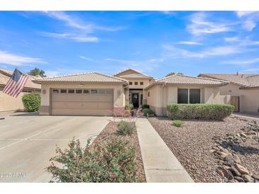 Inviting single-story home with a well-manicured front yard, neutral tones, and a convenient two-car garage at 8420 W Cherry Hills Dr, Peoria, AZ 85345
