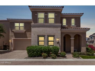 Charming two-story home with a neutral color palette, arched entry, and well-manicured landscaping at 9733 E Axle Ave, Mesa, AZ 85212