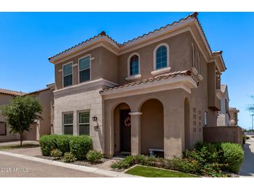 Charming two-story home features a tile roof, arched entryway, manicured landscaping, and beautiful stone accents at 9733 E Axle Ave, Mesa, AZ 85212