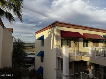 Condo's exterior showcasing its charming facade with awnings and a scenic view from the balcony at 12123 W Bell Rd # 337, Surprise, AZ 85378