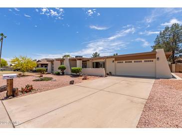 Single level home with a neutral color scheme, rock landscaping, and a two car garage at 4803 W Harmont Dr, Glendale, AZ 85302