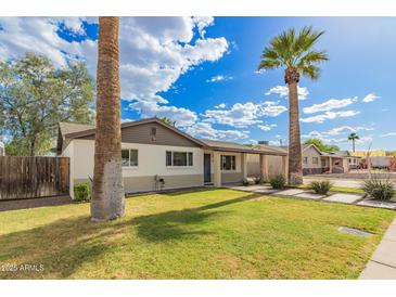 Attractive single-Gathering home featuring a lush lawn and mature desert landscaping at 6907 E Portland St, Scottsdale, AZ 85257