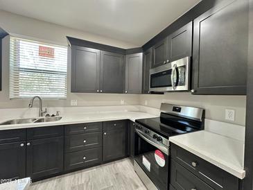 This kitchen is equipped with modern appliances, sleek cabinetry, and pristine white countertops at 11216 W Apache St, Avondale, AZ 85323