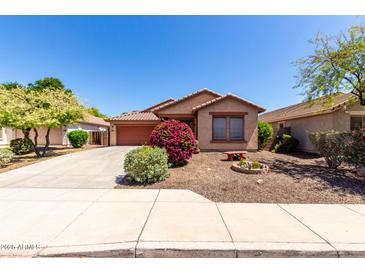 Charming single-story home with a well-manicured front yard and a two-car garage at 12838 W Desert Mirage Dr, Peoria, AZ 85383