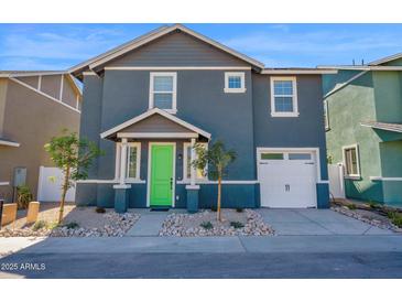 Charming two-story home showcasing modern architecture and a well-manicured front yard with a vibrant green door at 16875 N 12Th St # 33, Phoenix, AZ 85020