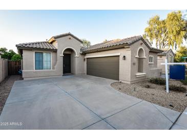 Inviting single-story home with a well-manicured lawn, neutral exterior, and a spacious driveway leading to a two-car garage at 21050 E Tierra Grande --, Queen Creek, AZ 85142