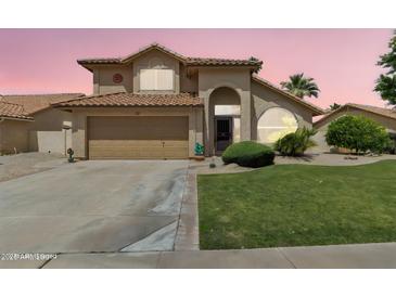 Charming two-story home featuring a well-maintained lawn and a two car attached garage at 2340 W Myrtle Dr, Chandler, AZ 85248