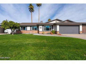Charming single-story home with a well-manicured lawn, desert landscaping, and attached two-car garage at 2430 E Hermosa Dr, Tempe, AZ 85282