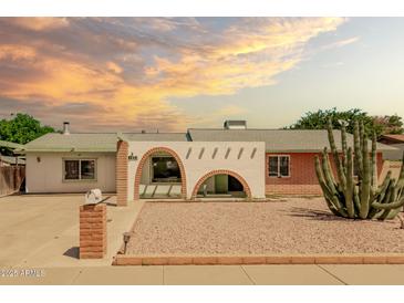 Charming single-story home featuring unique architectural details and desert landscaping with a decorative brick pillar mailbox at 3248 E Windrose Dr, Phoenix, AZ 85032