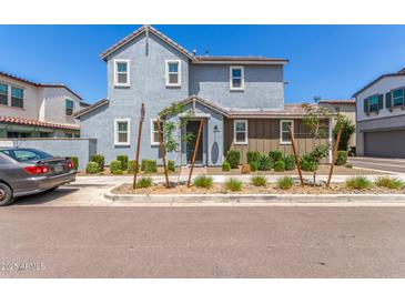 Charming two-story home featuring a combination of gray and brown siding with manicured landscaping at 4833 S Ferric --, Mesa, AZ 85212