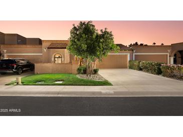 Charming single-story home with a well-manicured lawn and a two-car garage at 7710 N Via De Fonda St, Scottsdale, AZ 85258