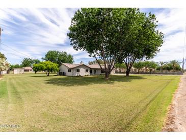 Expansive front yard and charming single-story home provide a peaceful and inviting atmosphere at 12548 E Cloud Rd, Chandler, AZ 85249