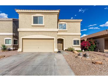 Two-story home with a two car garage, desert landscaping, and tan stucco at 337 N 103Rd Pl, Apache Junction, AZ 85120
